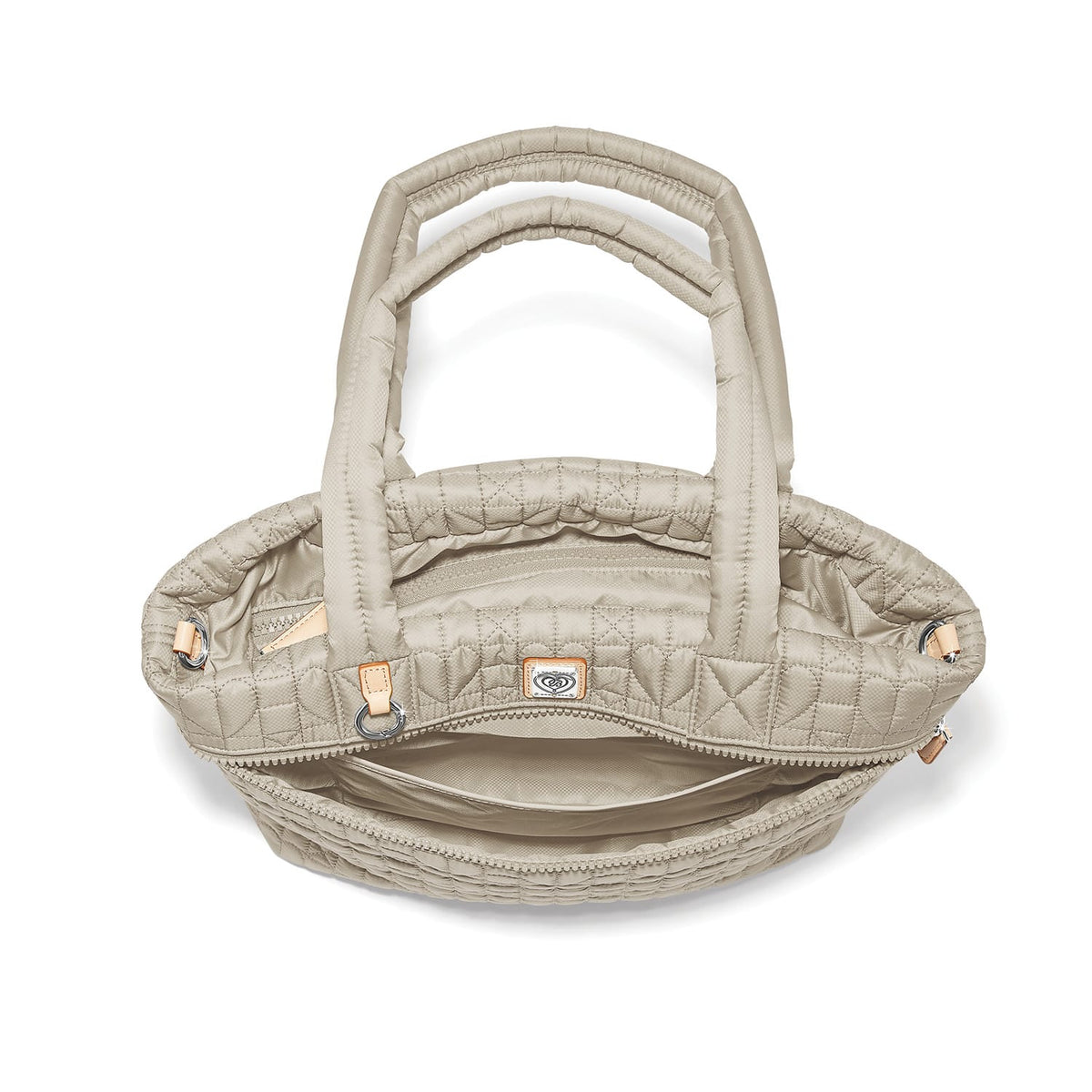 Brighton quilted handbag shown from above with open interior view, dual padded handles, and logo tag on a white background