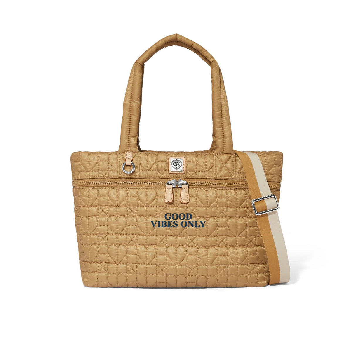 Brighton tote handbag in tan quilted heart pattern with Good Vibes Only text and striped crossbody strap on a white background