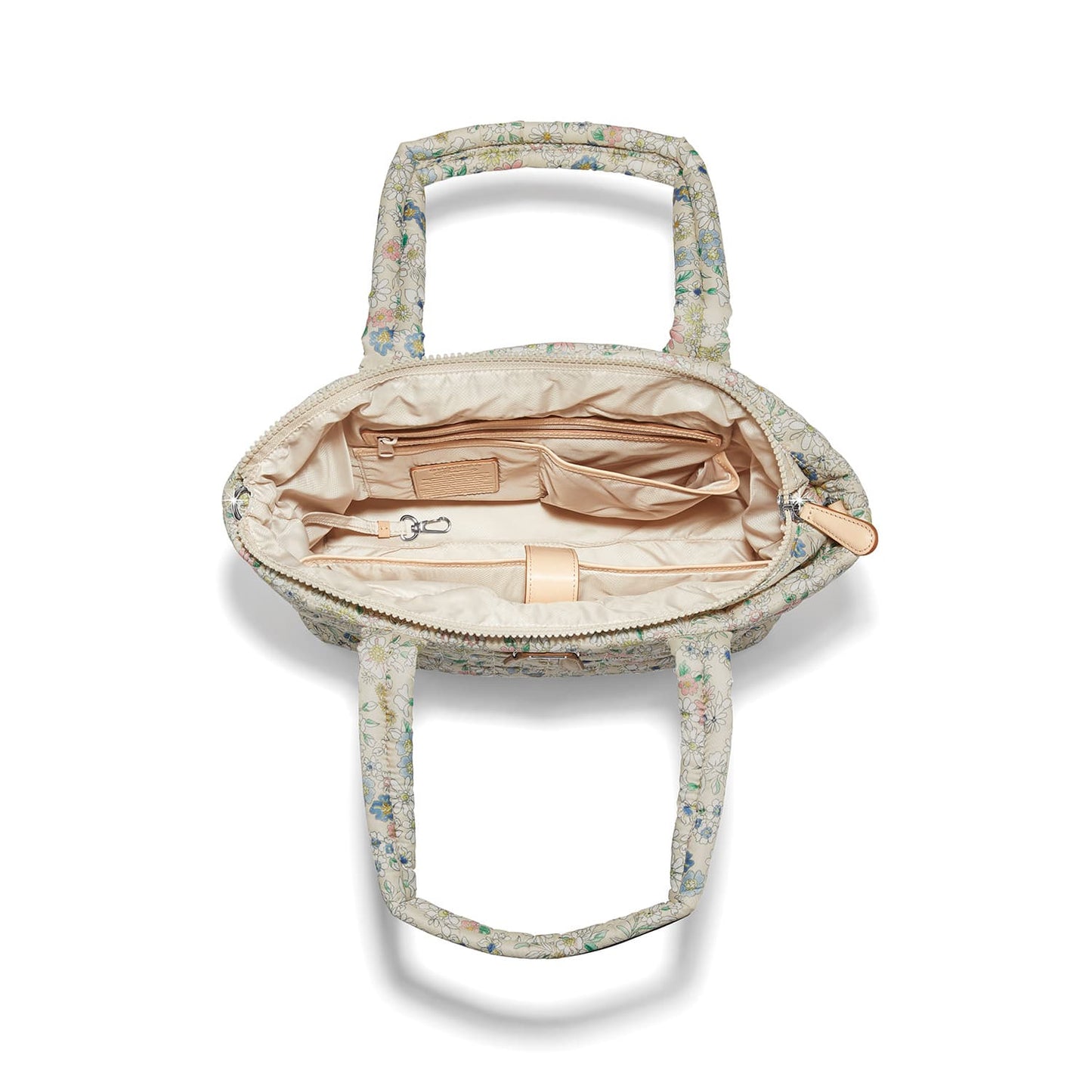 Brighton handbag interior view with floral print exterior, beige lining, zip pocket, and clip strap on a white background