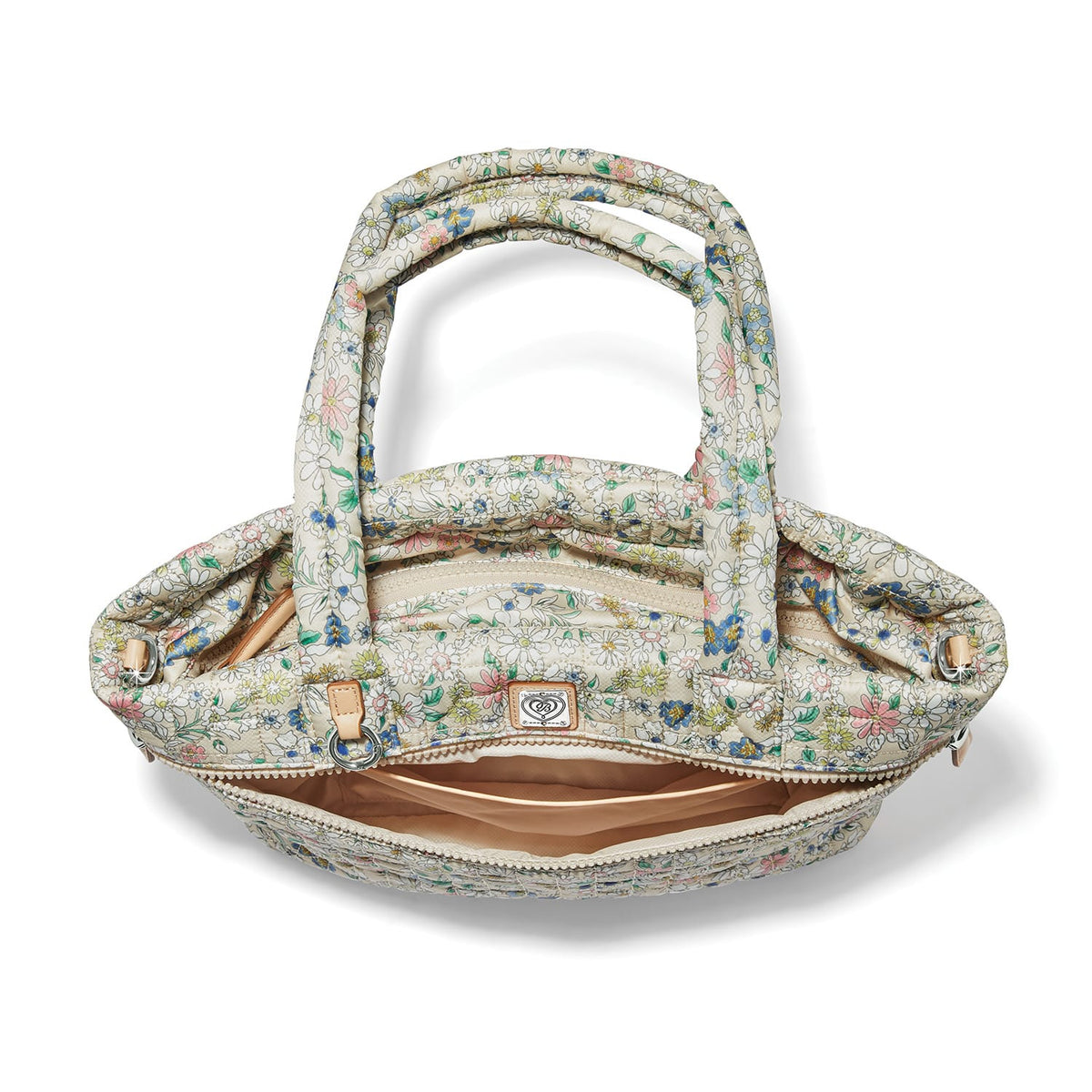 Brighton handbag interior view with floral print quilted fabric, zippered pocket, and tan lining on a white background