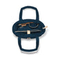 Brighton navy blue handbag interior view showing zippered pocket, leather trim accents, and fabric lining on a white background