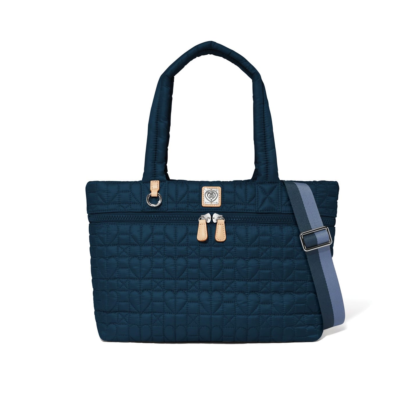 Brighton tote handbag in navy quilted heart pattern with dual handles and striped adjustable crossbody strap on a white background