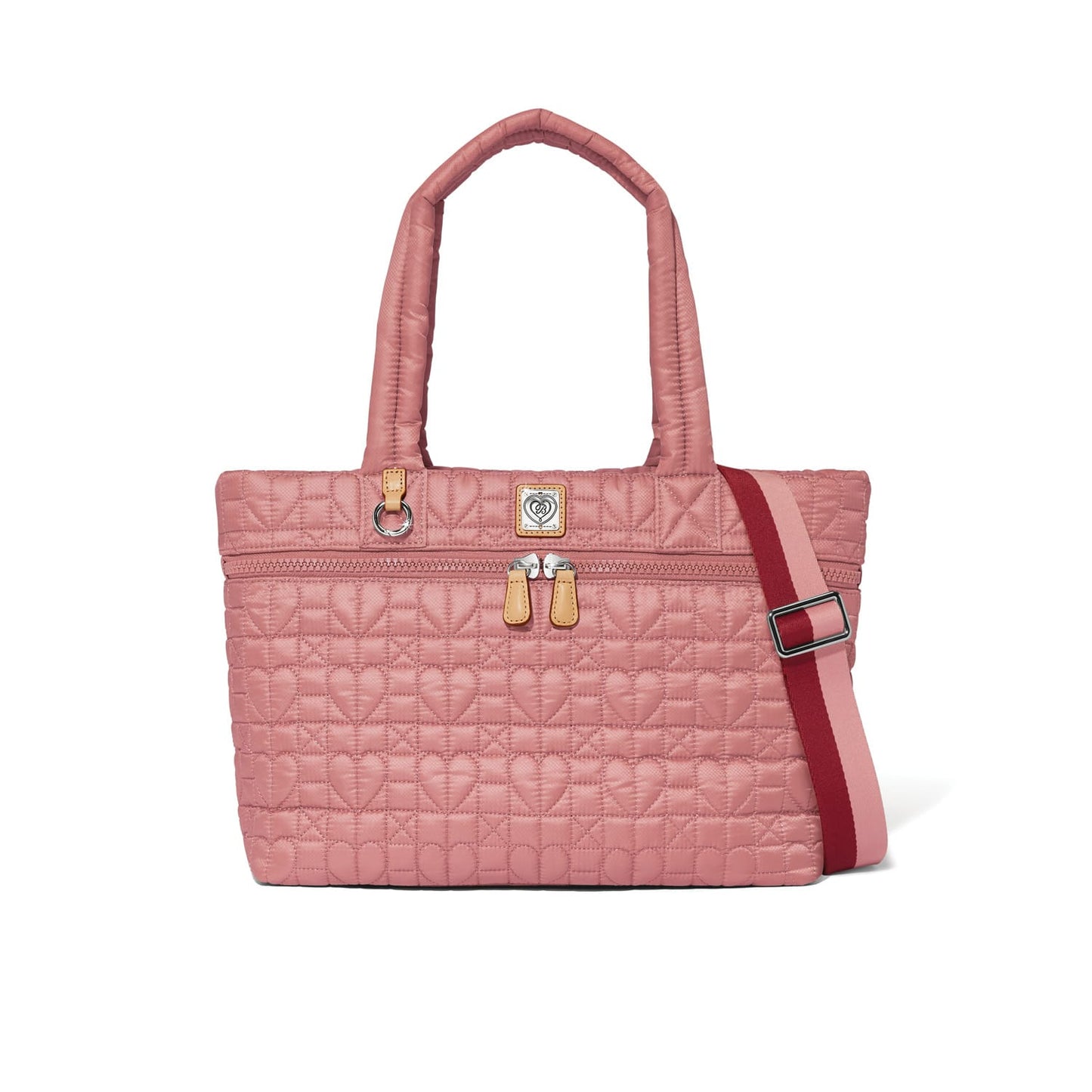 Brighton pink quilted tote handbag with heart pattern, dual handles, and red-pink crossbody strap on a white background