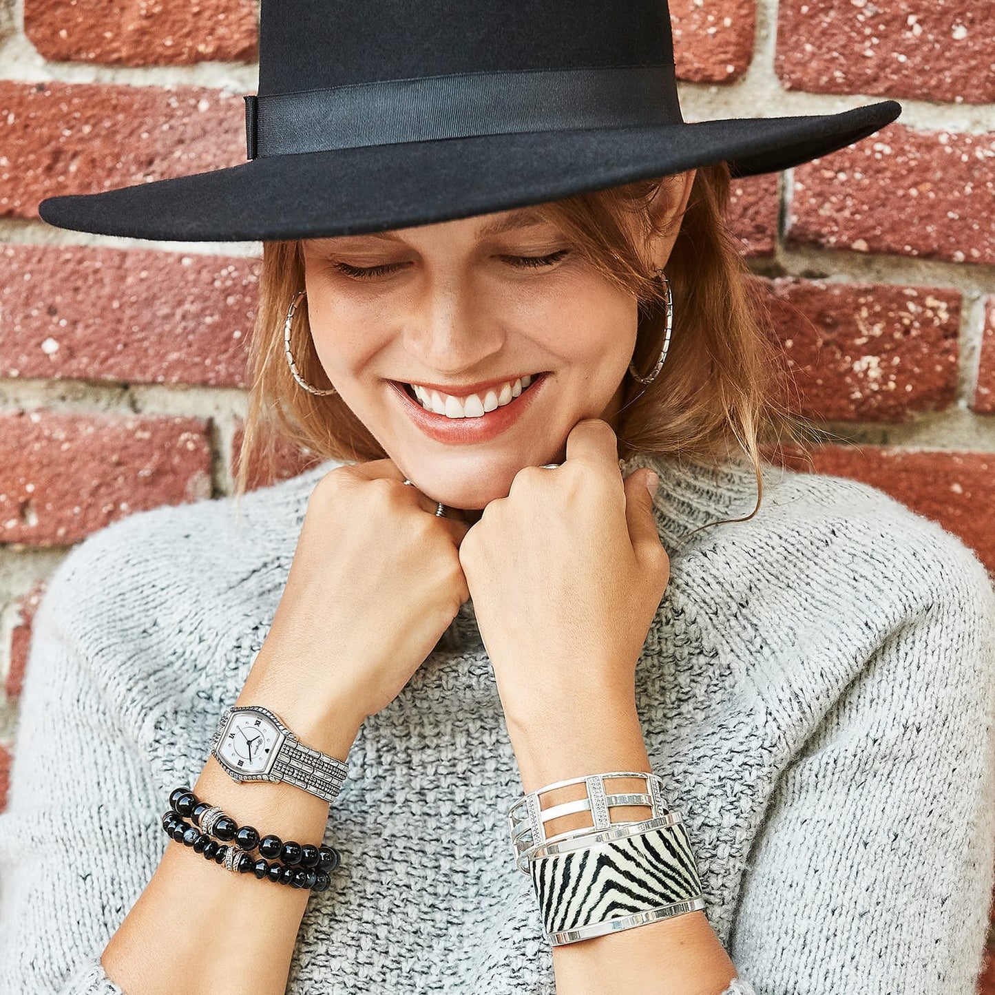 Model wearing a Brighton silver-plated watch with crystal accents and coordinating Brighton bracelets including black beads and zebra print