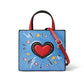 Brighton handbag with blue pop-art print, red heart applique, red handle, and adjustable strap on a white background