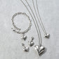 Brighton silver-plated heart jewelry set styled with chain bracelet and coordinating necklaces featuring crystal accents on gray stone
