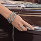 Model wearing Brighton silver-plated bangle bracelets with scroll and openwork designs paired with a silver knot ring
