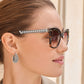 Model wearing Brighton tortoise sunglasses with silver-plated beaded temples paired with silver-plated beaded hoop earrings