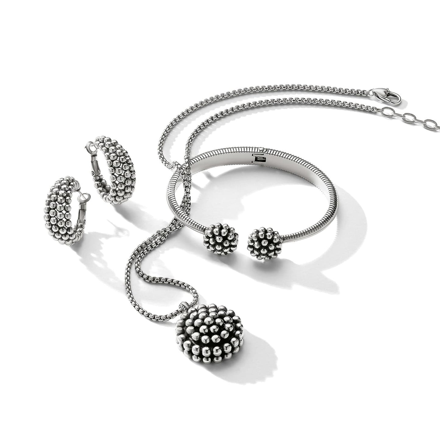 Brighton silver-plated jewelry set styled with beaded pendant necklace, hoop earrings, and matching cuff bracelet on white background