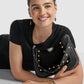 Model with a Brighton black leather handbag featuring gold and silver-tone studs and medallion accent
