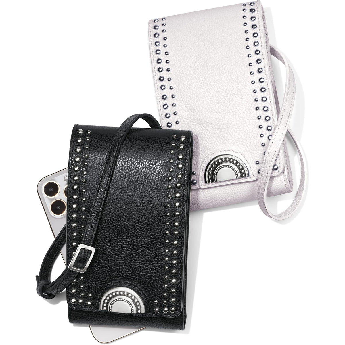 Brighton crossbody phone bags in black and white pebbled leather with silver-tone studs and medallion accents on a white background