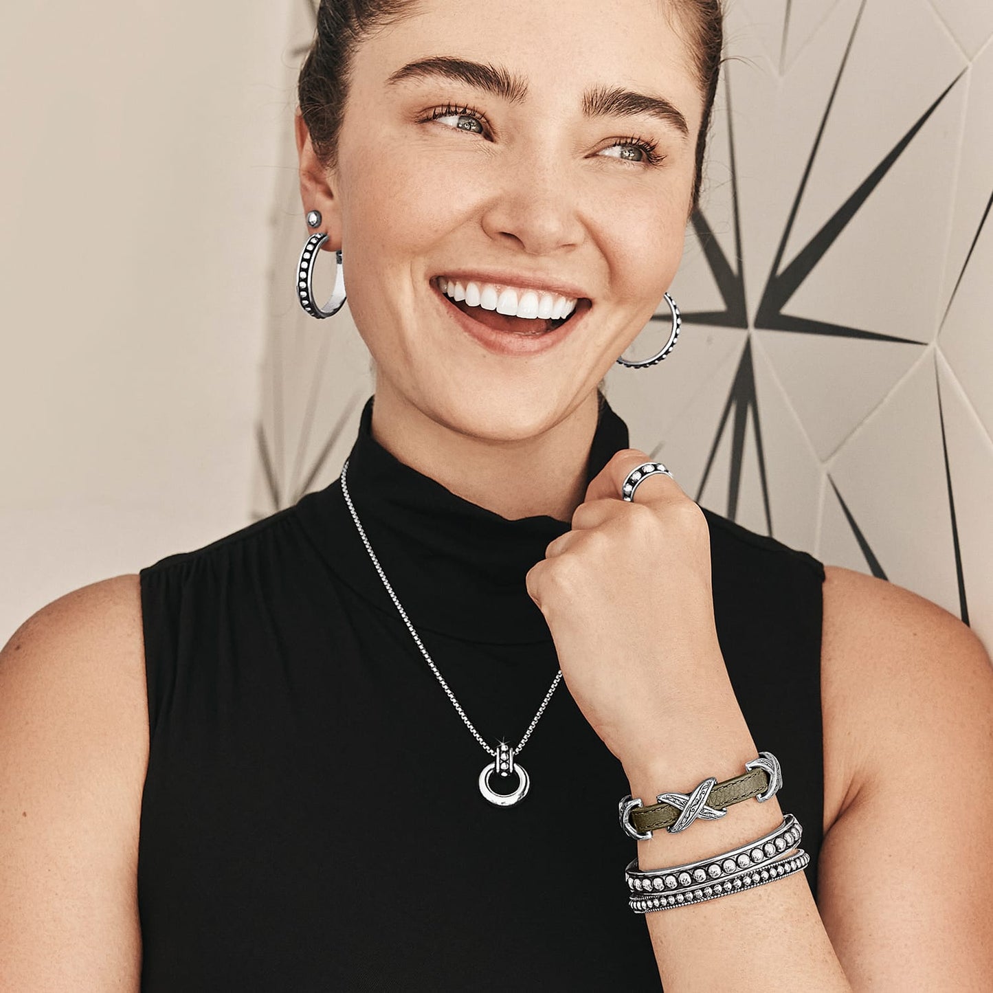 Model wearing Brighton silver-plated beaded hoop earrings with coordinating Brighton pendant necklace, bracelets, and ring accessories