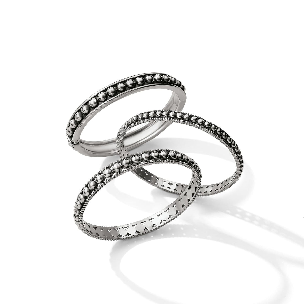 Brighton set of three silver-plated bangle bracelets with beaded and cutout heart designs on a white background