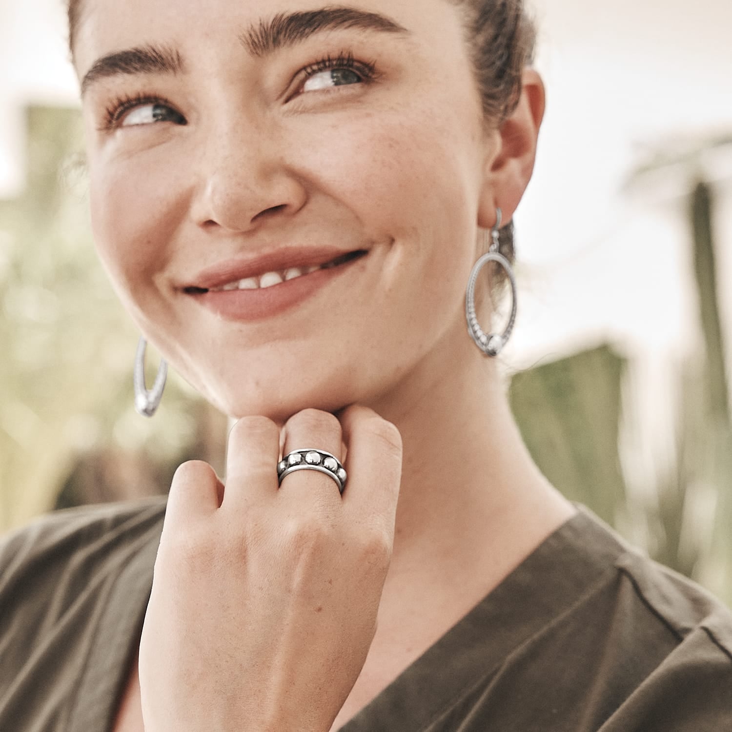 Model wearing Brighton silver-plated oval drop earrings and hoop earrings paired with a beaded silver-plated ring