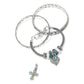 Brighton silver-plated bangles styled with a beaded charm bracelet and gold-plated enamel cross charm on white background