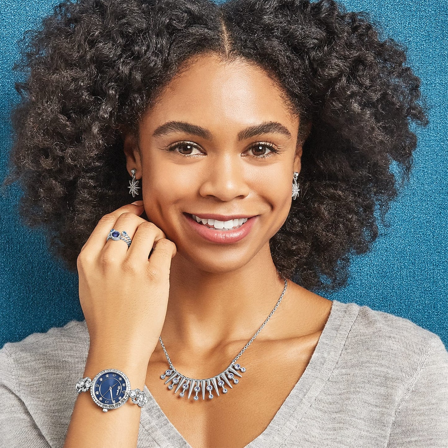 Model wearing Brighton silver-plated starburst drop earrings with crystals and coordinating Brighton accessories including watch, necklace, and rings