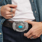 Model wearing a Brighton brown leather belt with ornate silver-tone buckle featuring a turquoise center stone