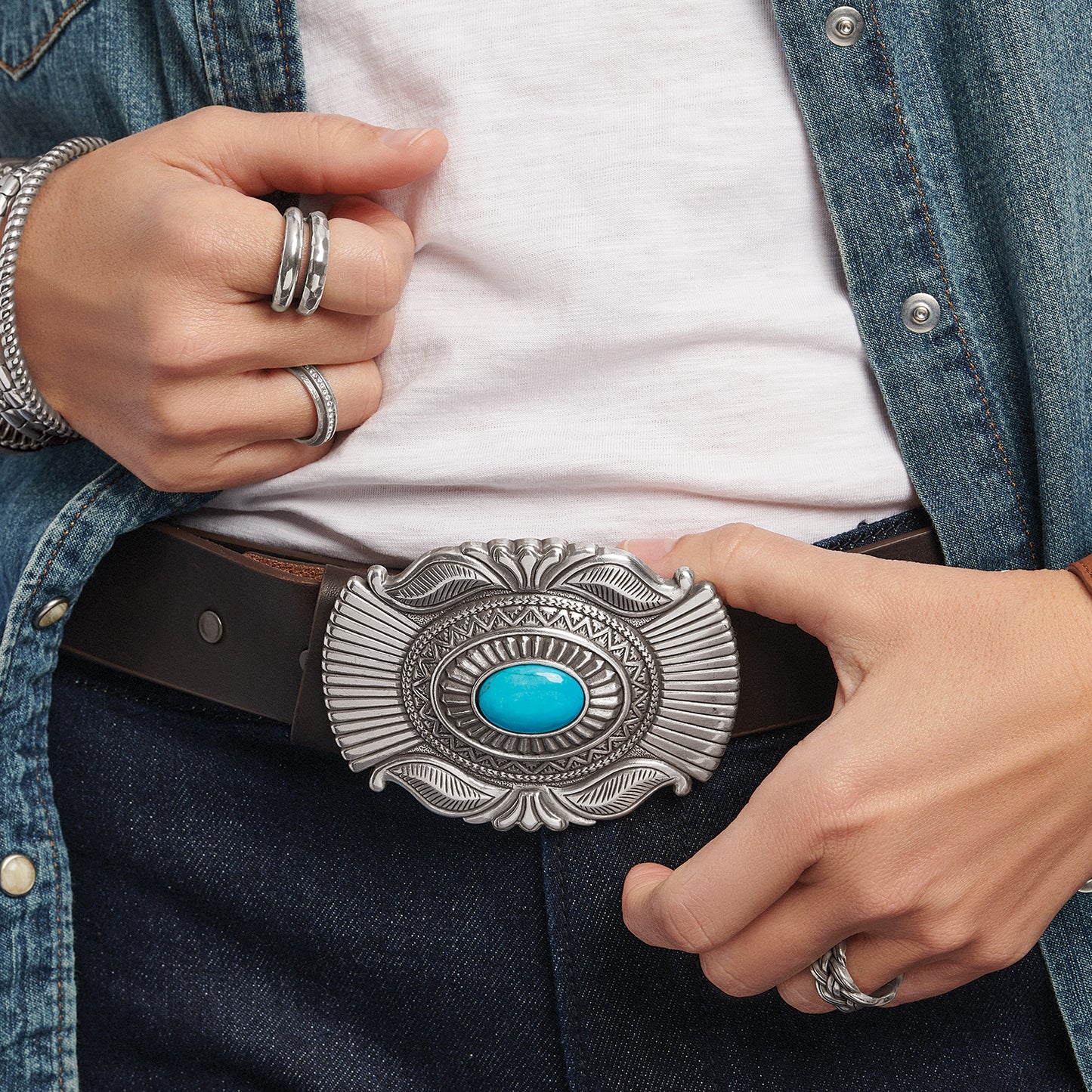 Model wearing a Brighton brown leather belt with ornate silver-tone buckle featuring a turquoise center stone