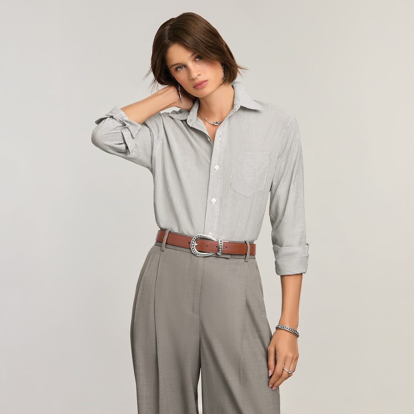 Model wearing a Brighton brown leather belt with ornate silver-tone buckle and studded keeper detail
