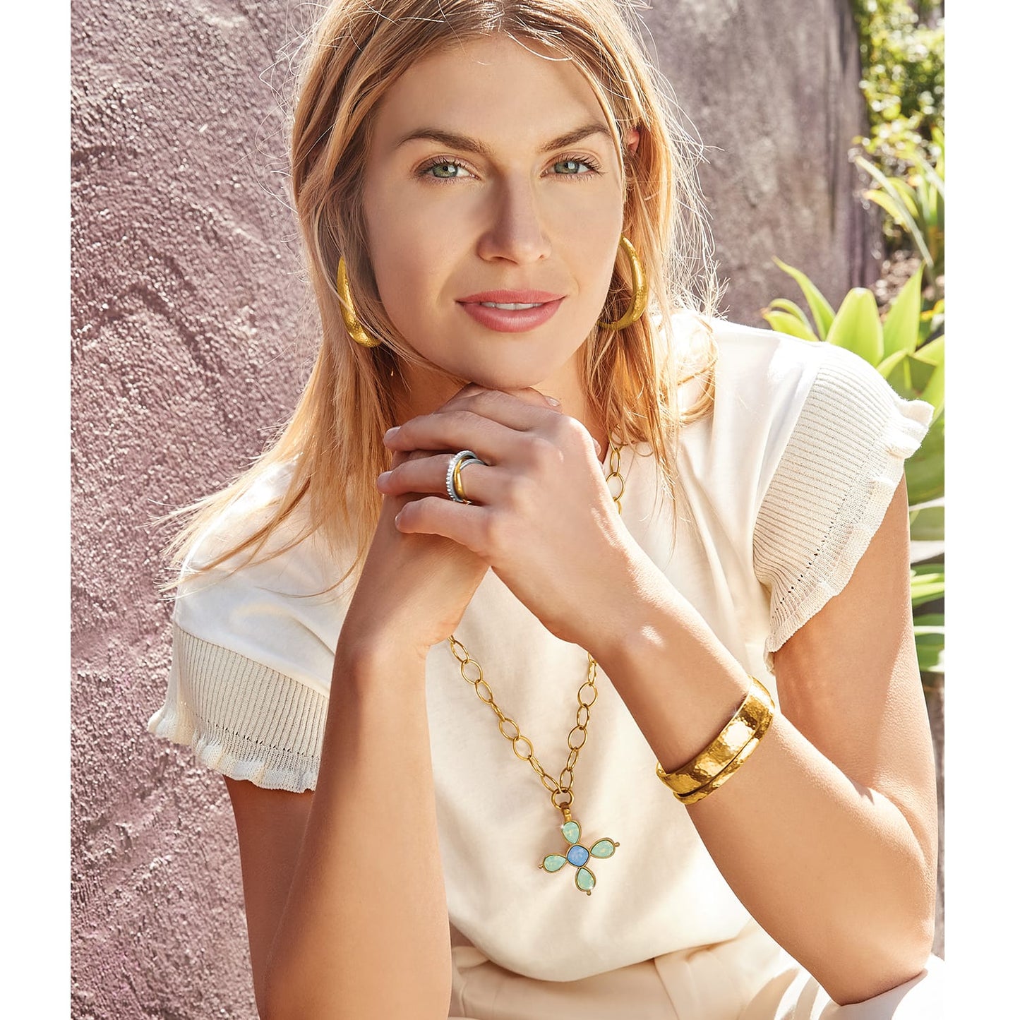 Model wearing a Brighton gold pendant necklace with opal flower charm and coordinating Brighton accessories