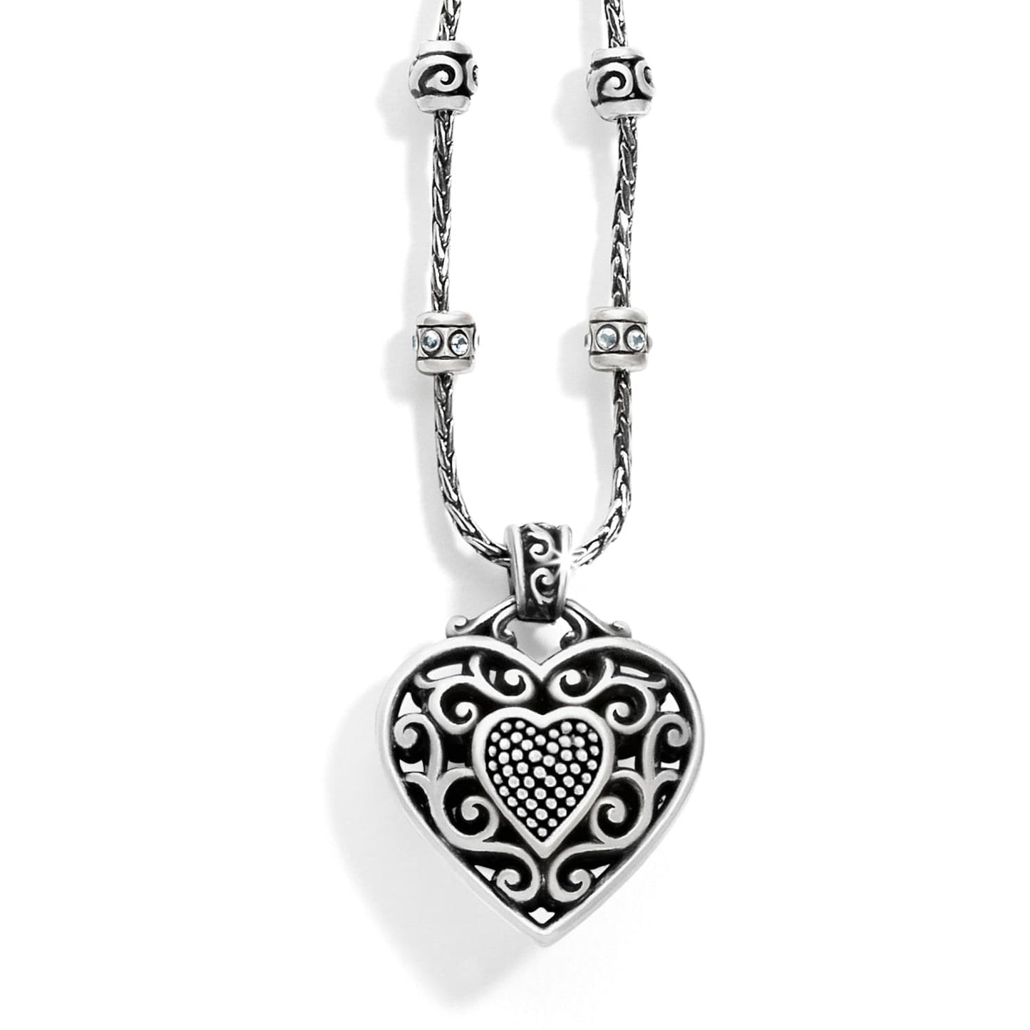 Brighton pendant necklace with silver-plated filigree heart, crystal-accented beaded stations, and rope chain on a white background