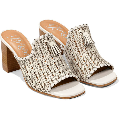 Brighton heeled mule sandals with cream woven leather uppers, tassel accents, and stacked wood block heels on a white background