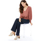 Model wearing Brighton woven heeled mules with tassel detail, paired with dark wide-leg jeans and blouse