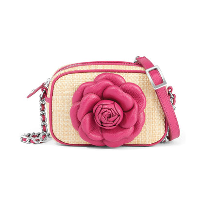 Brighton crossbody handbag in natural raffia with pink leather rose appliqué and silver-tone chain strap on a white background