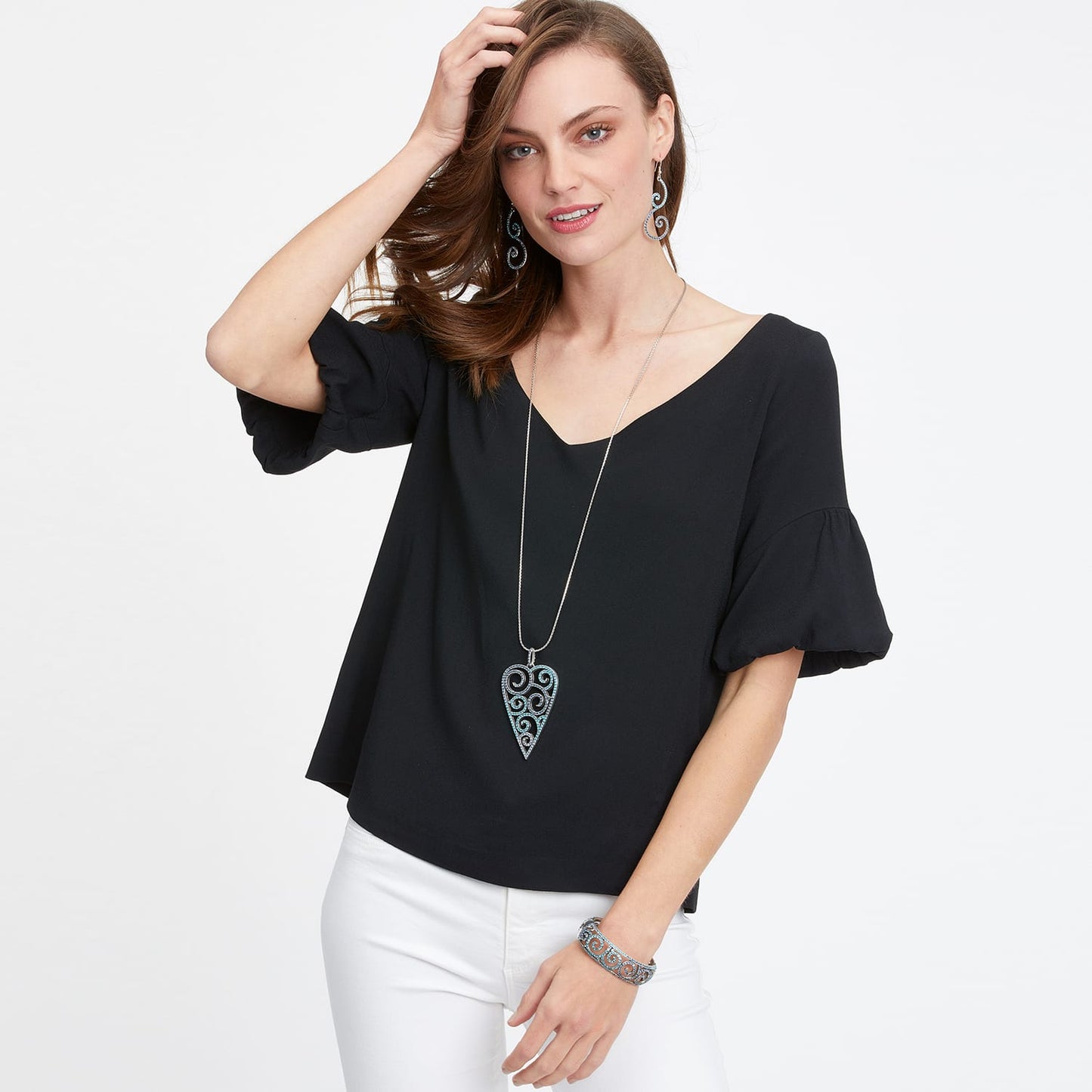 Model wearing a Brighton silver-plated heart pendant necklace with scroll detail, matching drop earrings, and cuff bracelet