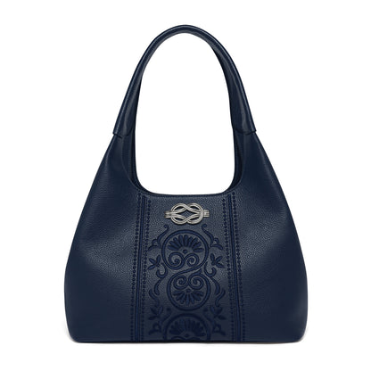 Brighton navy blue leather handbag with embossed floral panel and silver-tone knot emblem on a white background
