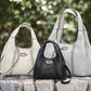 Brighton leather handbags in cream and black with braided stitching details and silver-tone knot emblems on stone