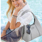 Model with a Brighton gray leather handbag with silver knot accent and whipstitch trim, holding sunglasses