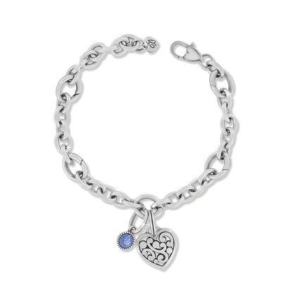 Brighton charm bracelet with silver-plated chain, filigree heart charm, and blue crystal charm on a white background
