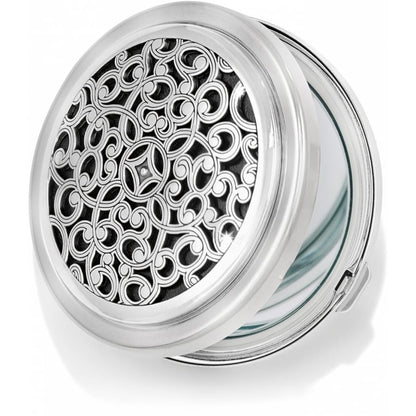 Brighton compact mirror with silver-tone scrollwork filigree design on hinged round case on a white background