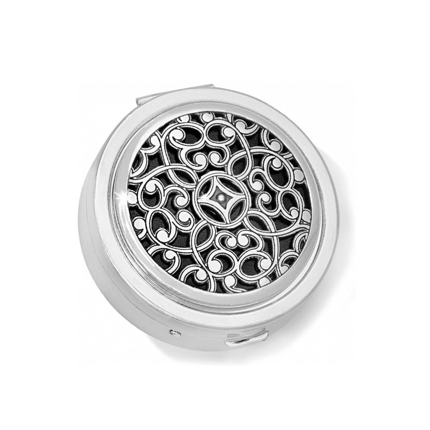 Brighton round pill box with silver-tone scrollwork filigree design over black inlay on a white background