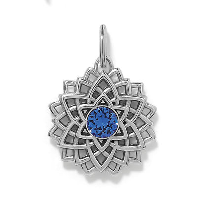 Brighton silver-plated lotus charm with blue crystal center and layered openwork petal design on a white background