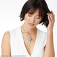 Model wearing a Brighton silver-plated pendant necklace with round medallion charm, bar charm, and blue stone