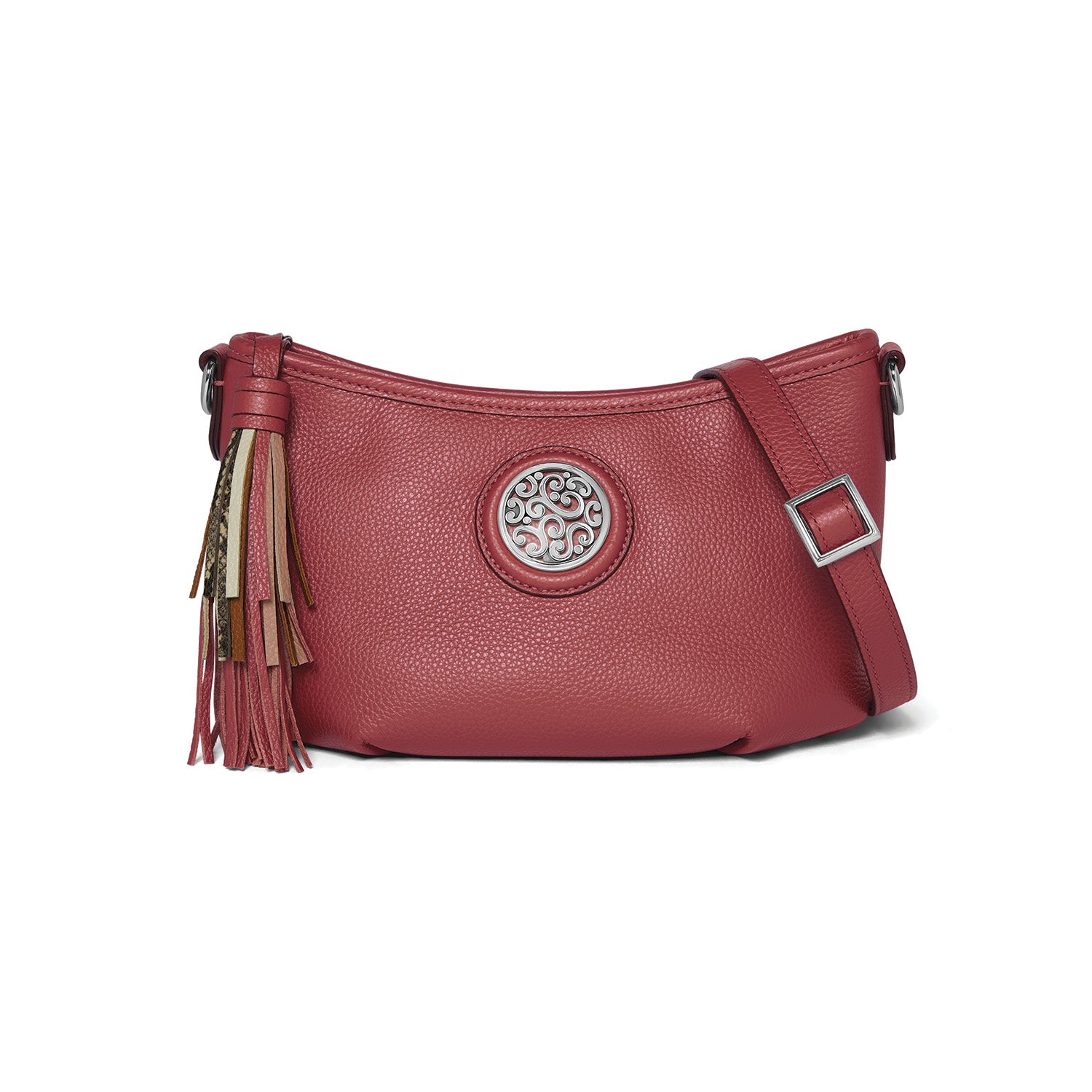 Brighton crossbody handbag in red pebbled leather with silver-tone scroll medallion, multicolor tassel, and adjustable strap on a white background