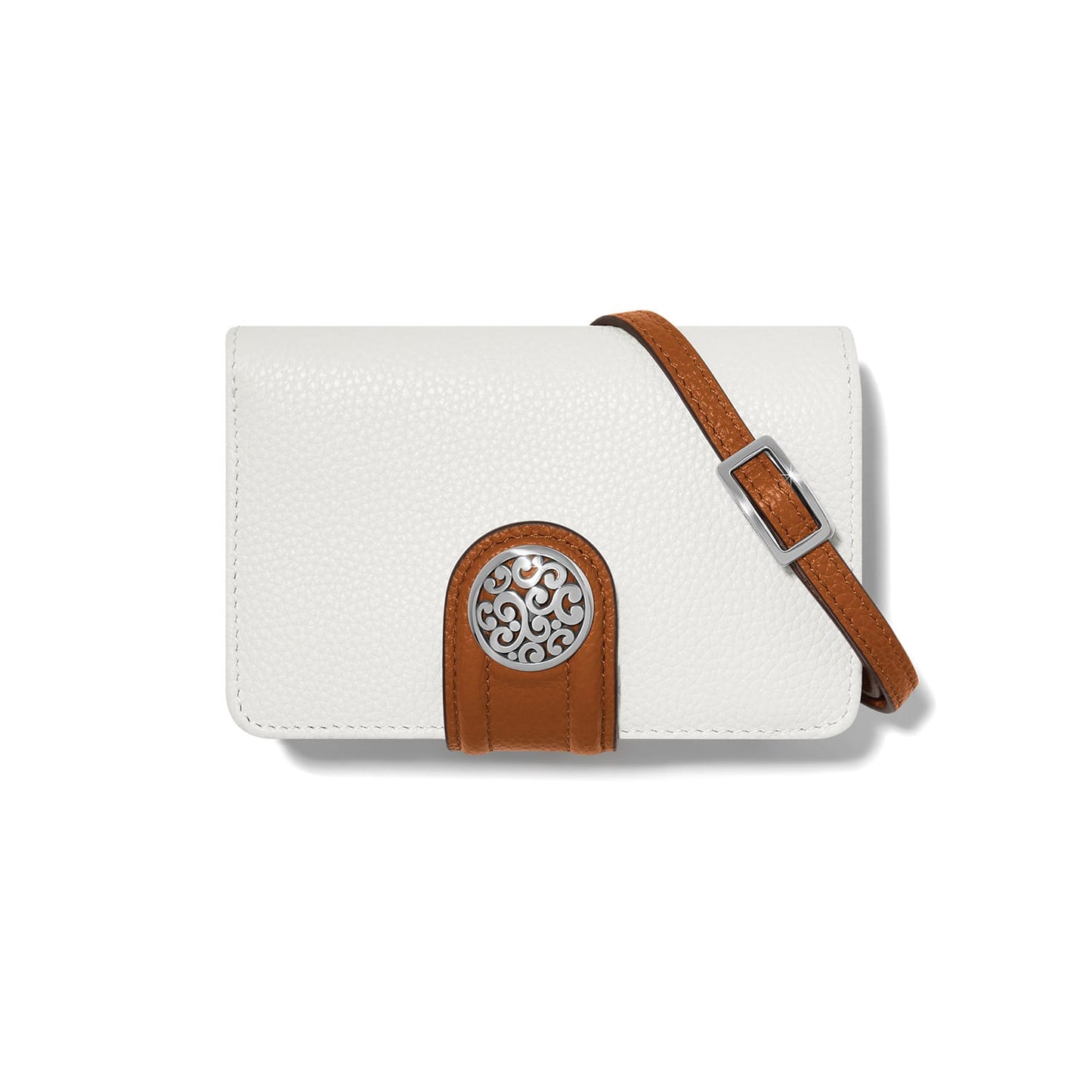 Brighton crossbody handbag in white pebbled leather with tan tab, silver-tone medallion, and adjustable strap on a white background