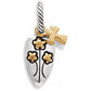 Brighton charm shaped like a garden trowel with gold-tone flowers and cross accent on a white background