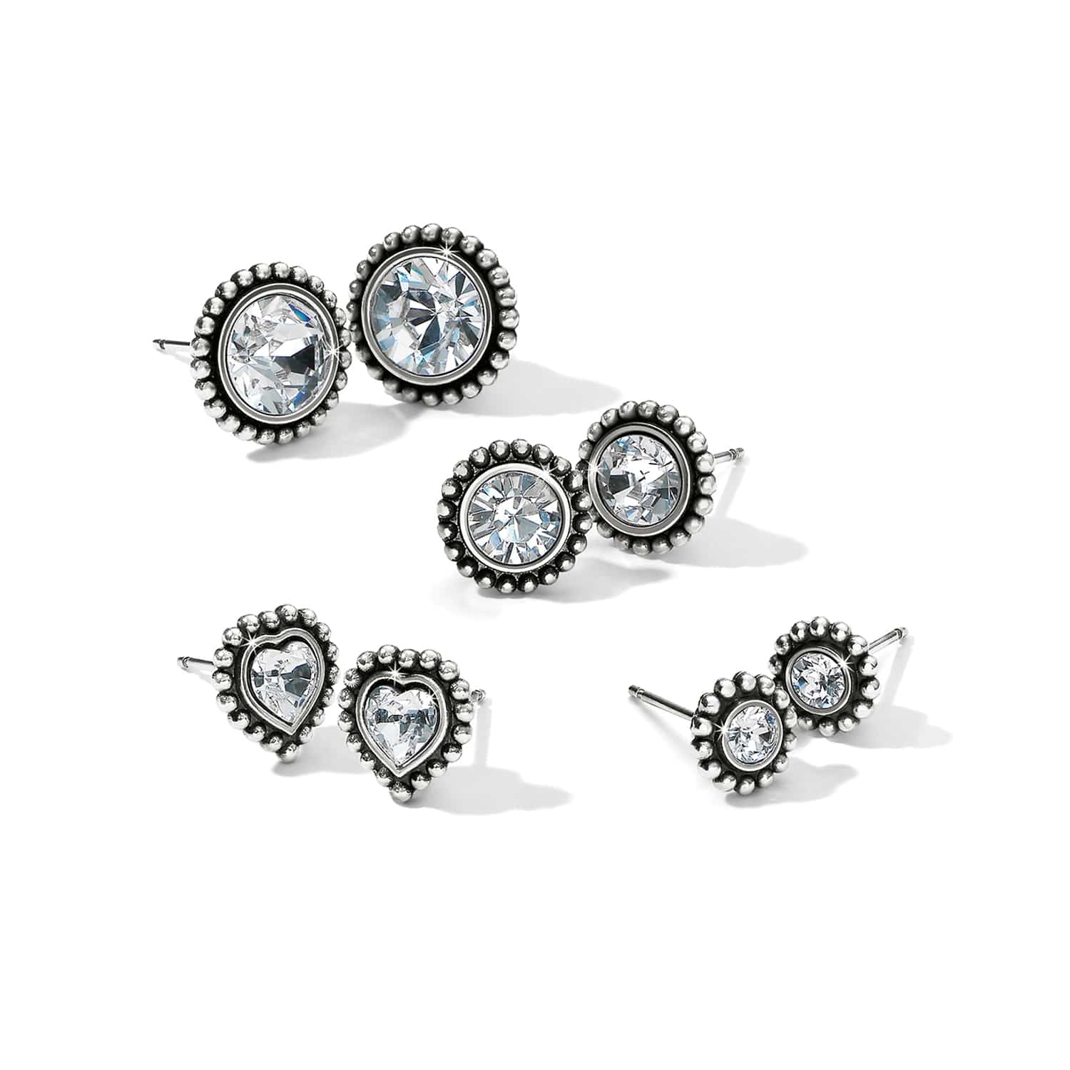 Brighton stud earrings set with crystals in silver-plated beaded frames in round and heart shapes on a white background