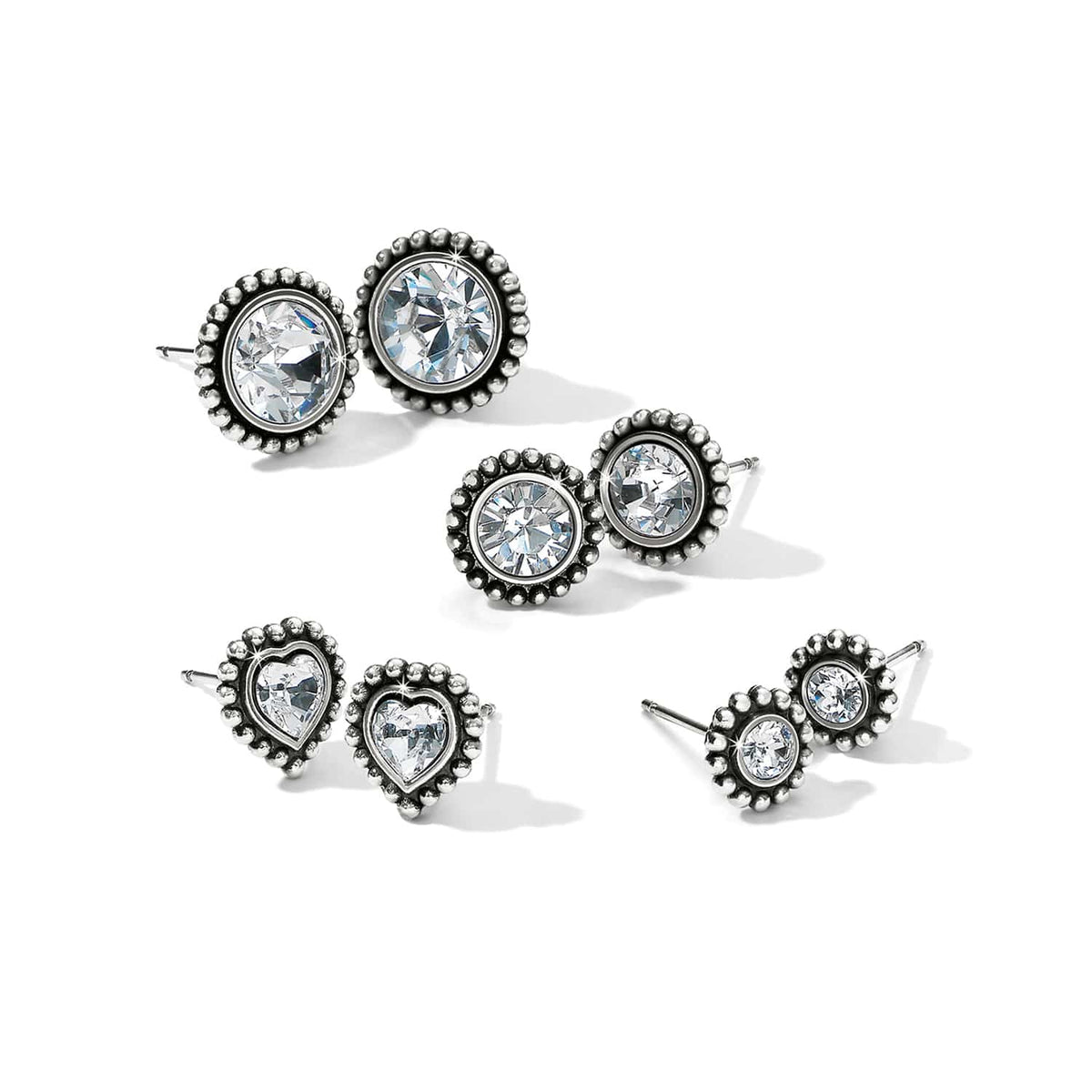 Brighton stud earrings set with crystals in silver-plated beaded frames in round and heart shapes on a white background