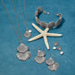 Brighton silver-plated shell jewelry set styled with a starfish and pearl accents on a blue background