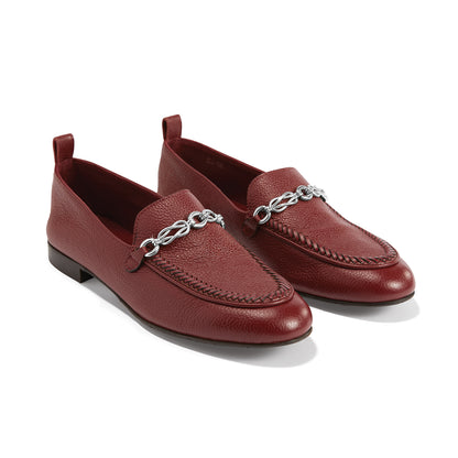 Brighton red leather loafers with silver-tone chain bit detail and whipstitched trim on a white background