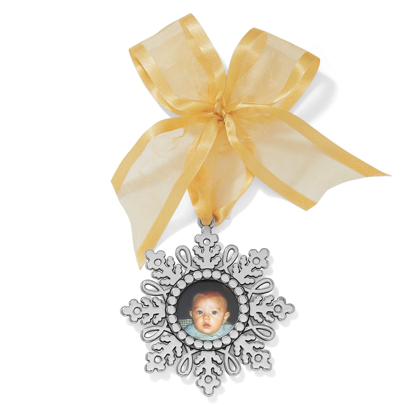 Brighton silver-plated snowflake photo ornament with central baby photo frame and gold organza ribbon bow on a white background