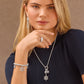 Model wearing a Brighton silver-plated snowflake pendant necklace with crystals and coordinating Brighton accessories