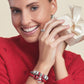 Model wearing a Brighton silver-plated charm bracelet with red enamel beads and coordinating Brighton accessories