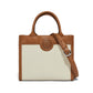 Brighton handbag in cream and cognac leather with whipstitch trim, medallion accent, and adjustable strap on a white background