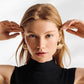 Model wearing Brighton gold-plated drop earrings with layered fan-shaped shell motifs and textured detailing