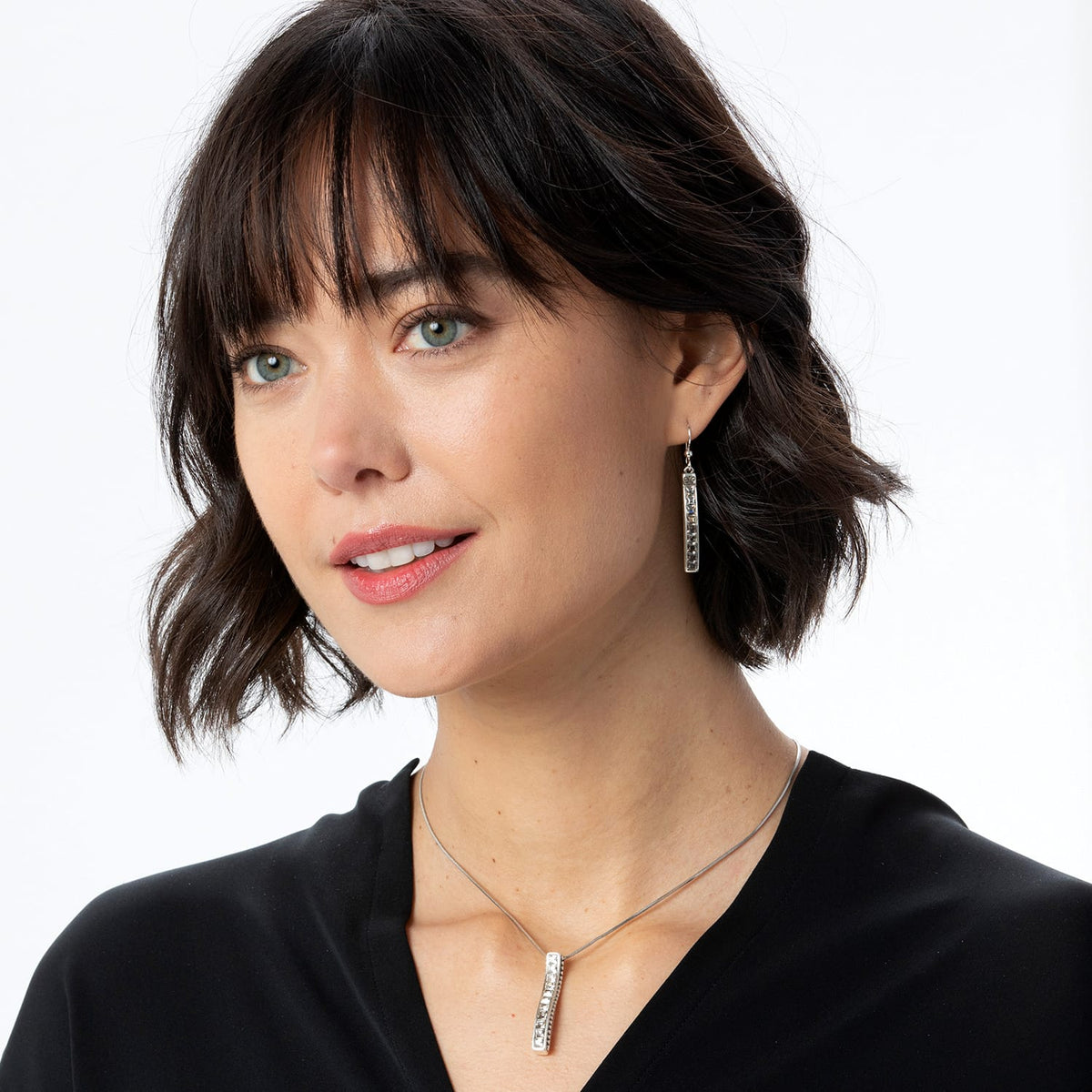 Model wearing a Brighton silver-plated drop necklace with crystal bar pendant paired with matching crystal drop earrings